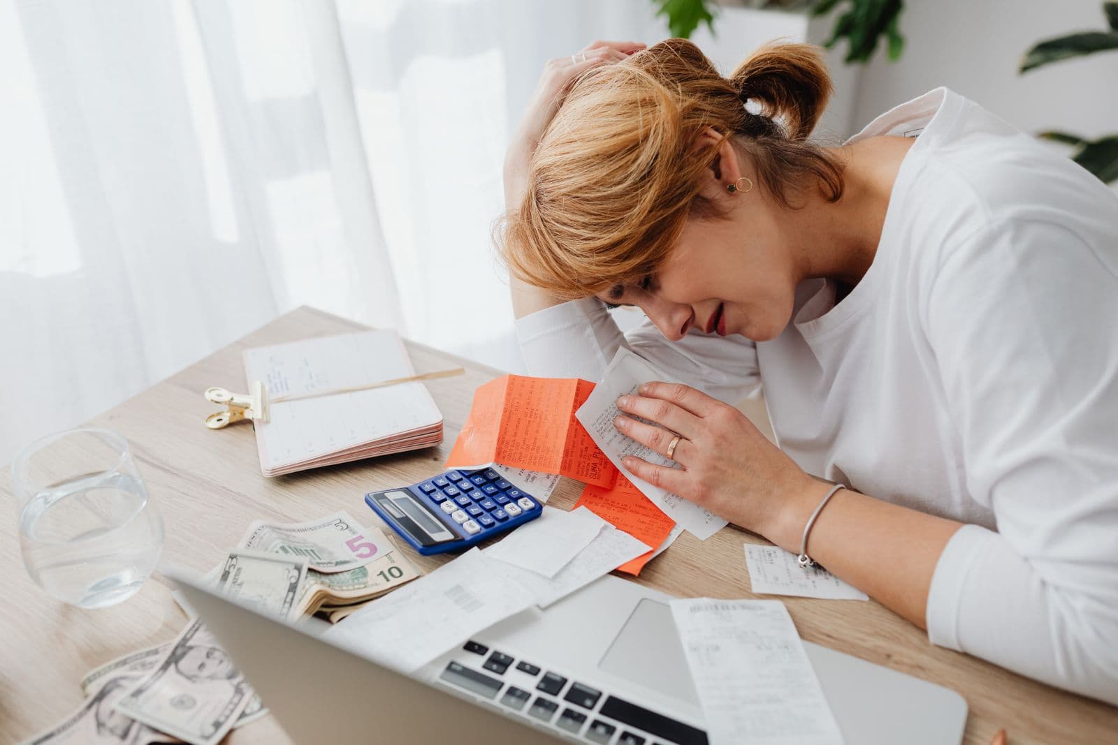 Person reviewing receipts and invoices at a desk while calculating event costs