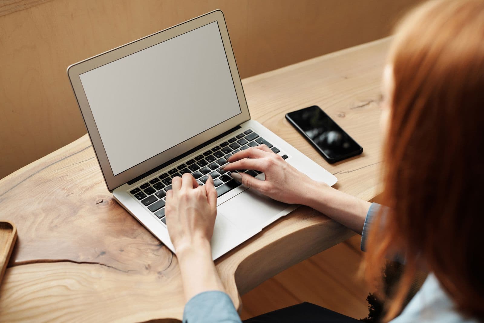 Person typing on a laptop while comparing event management software