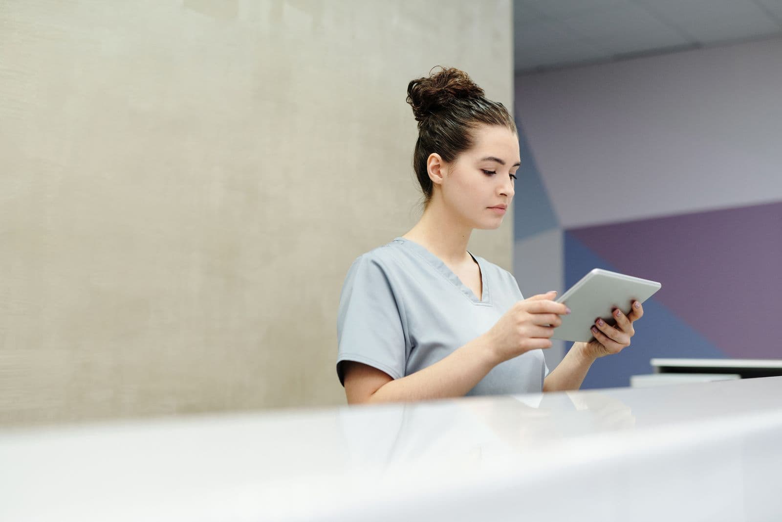 Receptionist using a tablet to check in a guest at an event registration desk