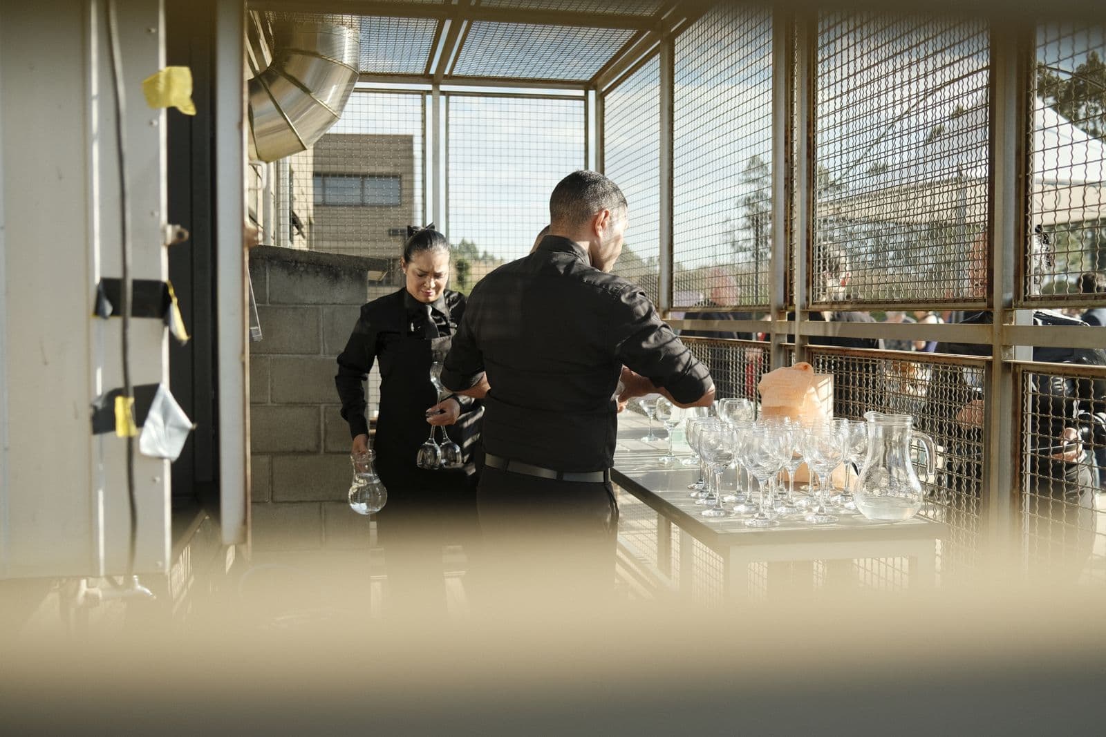 Catering staff setting up tables and place settings before an event