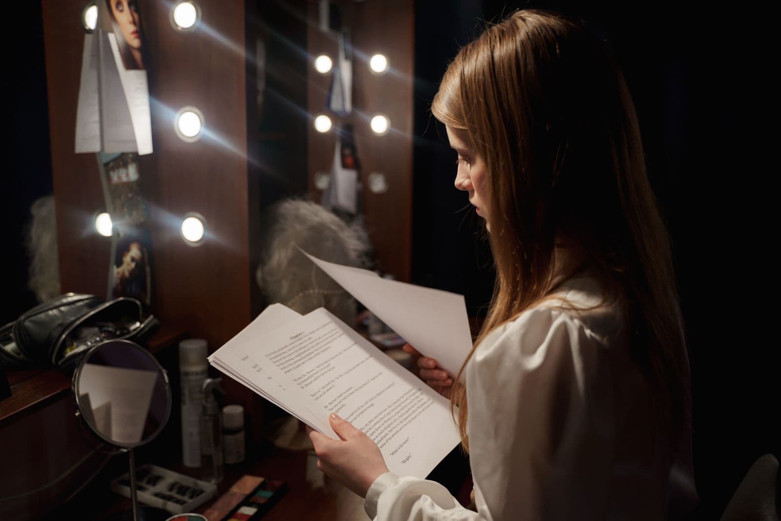Stage manager holding a clipboard backstage, reviewing a run of show cue sheet